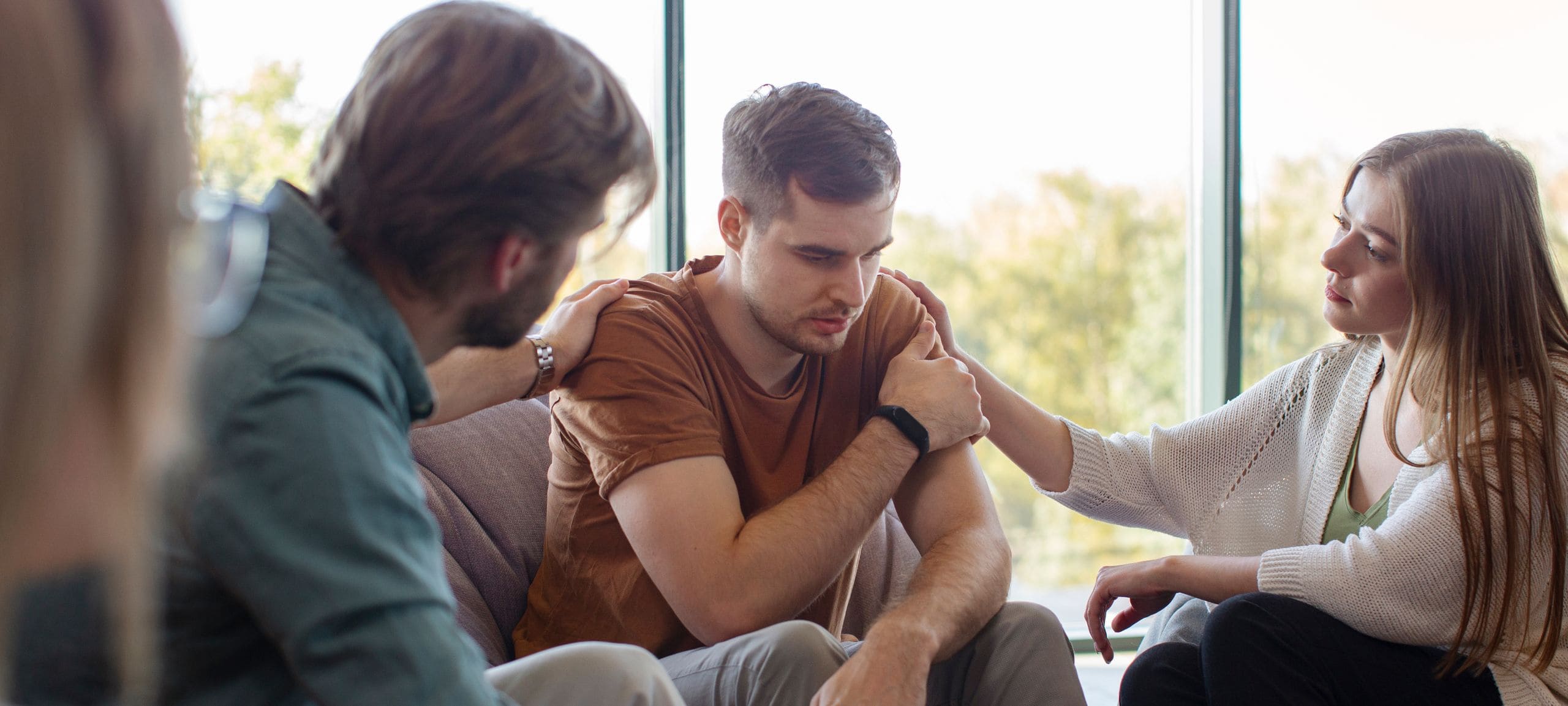 Young man receiving support from friends at rehab in Peachtree Corners, GA.